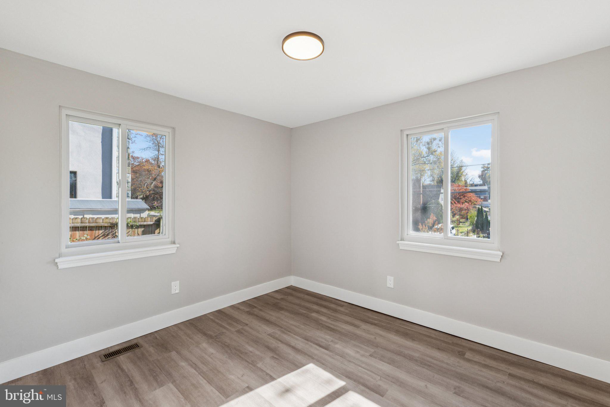 10101 Greeley Avenue Silver Spring, MD 20902 - Photo 11 of 25 a view of an empty room with wooden floor and a window