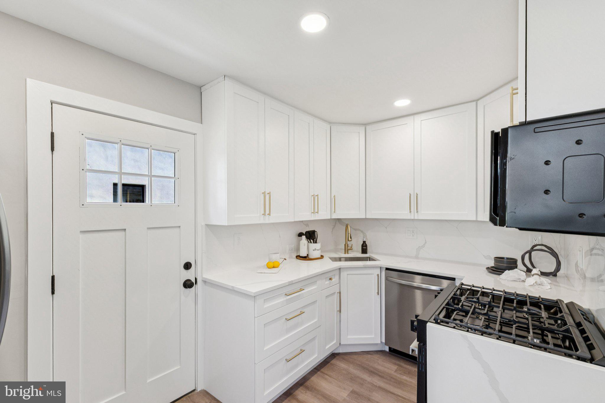 10101 Greeley Avenue Silver Spring, MD 20902 - Photo 4 of 25 a kitchen with granite countertop white cabinets and white appliances