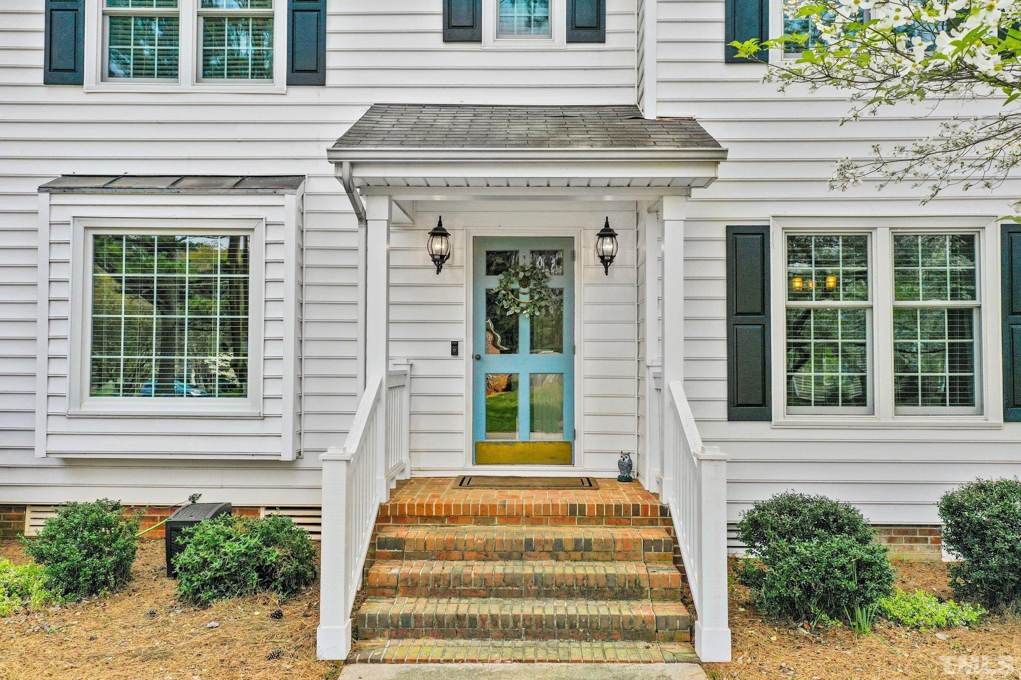 6212 Wynbrook Way Raleigh, NC 27612 - Photo 2 of 45 a front view of a house with a window and potted plants