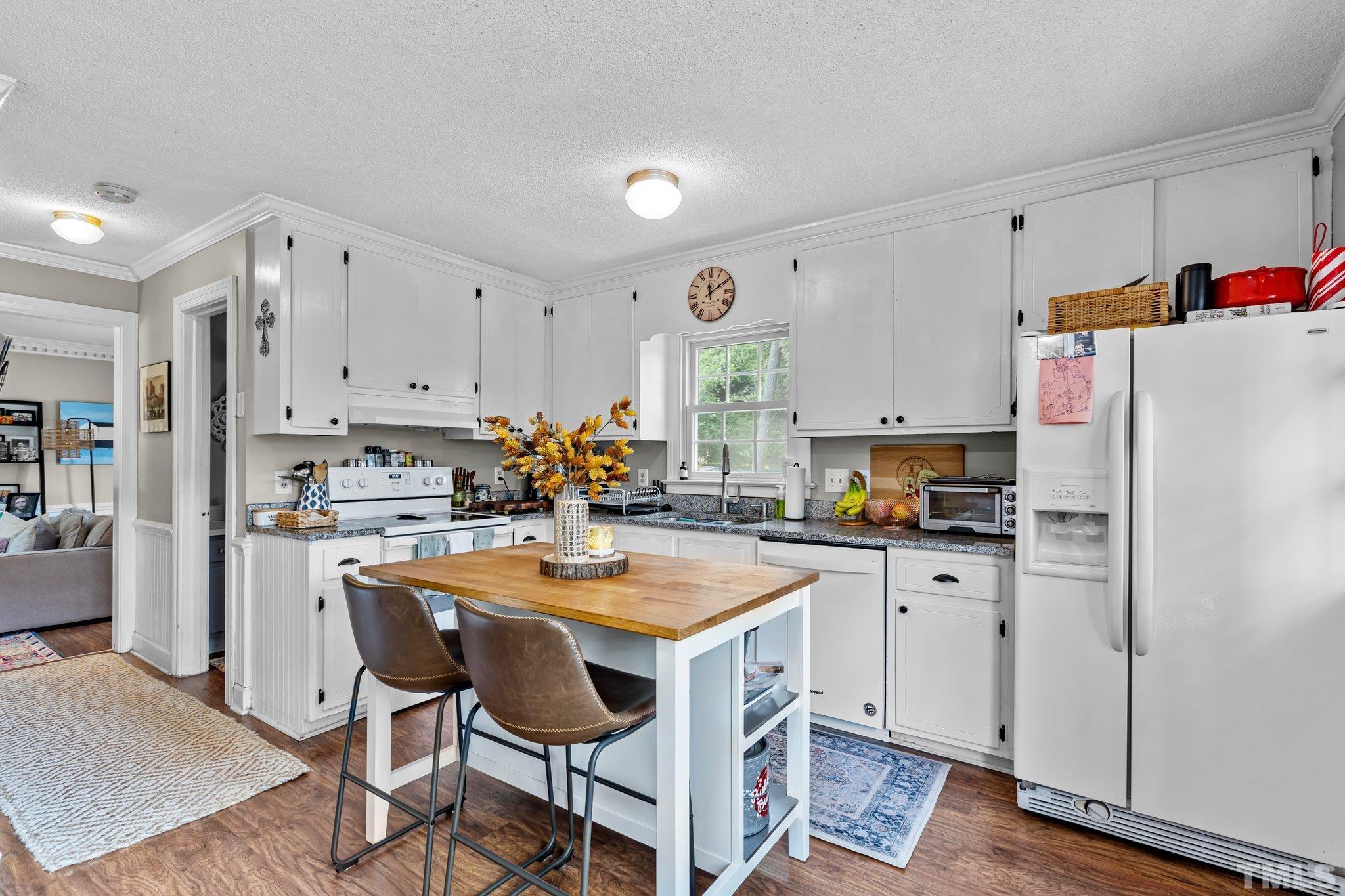 6212 Wynbrook Way Raleigh, NC 27612 - Photo 8 of 45 a kitchen with stainless steel appliances a refrigerator a stove a sink dishwasher and white cabinets with wooden floor