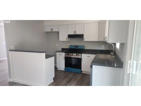 a kitchen with stainless steel appliances a stove a microwave a sink and cabinets