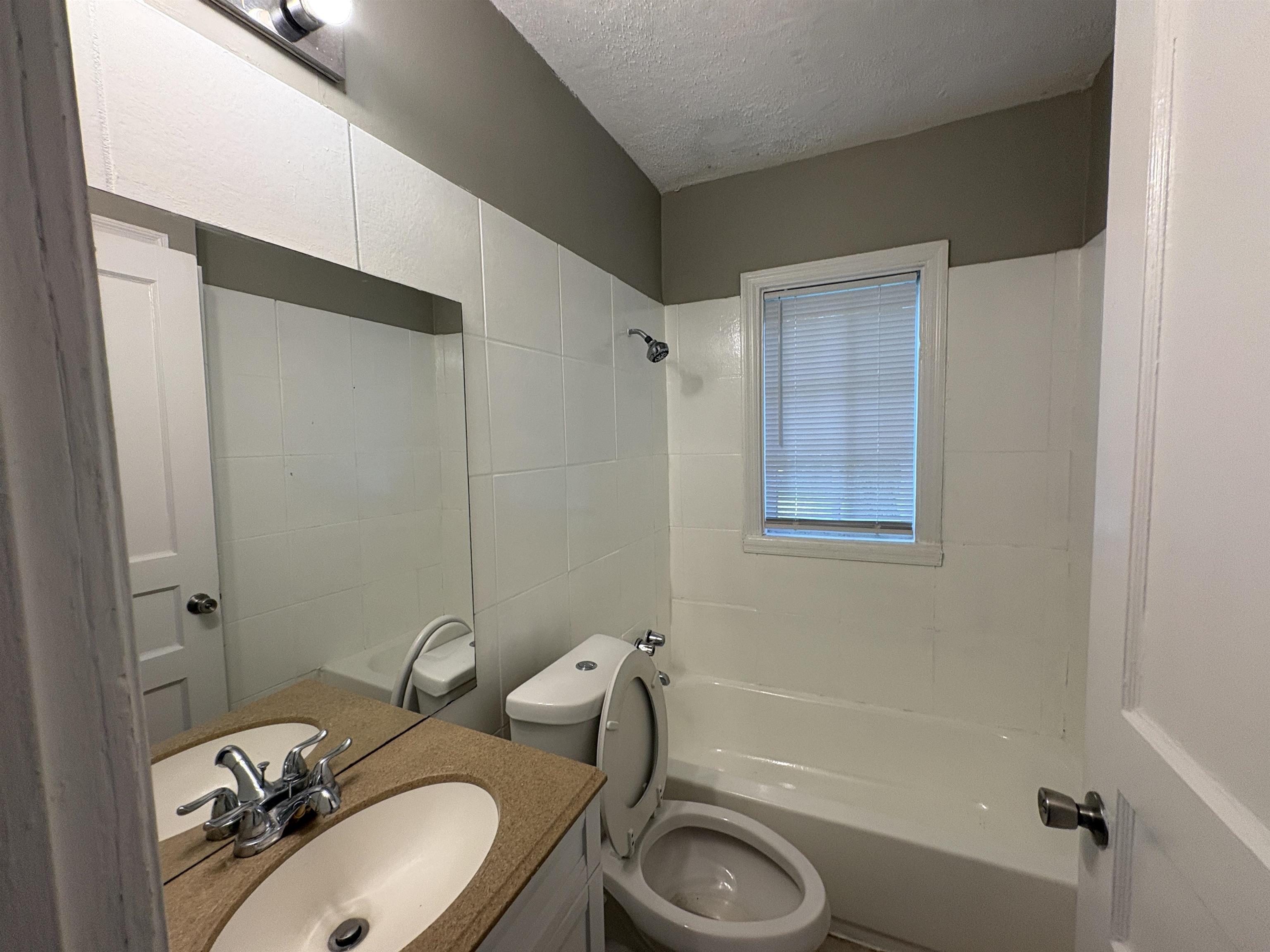 3391 Hadley Road Memphis, TN 38111 - Photo 11 of 11 Bathroom featuring a tub/shower combination, white wall tiling, and a vanity with an integrated sink and stone-finish countertop
