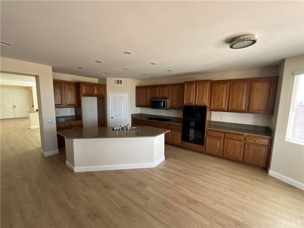 18388 Hidden Ranch Road Riverside, CA 92508 - Photo 12 of 46 a large kitchen with cabinets wooden floor and a refrigerator