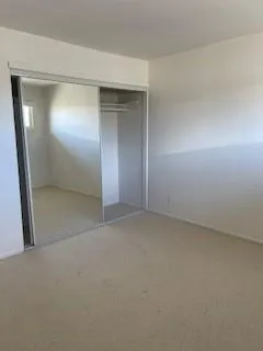 an empty room with closet and mirror