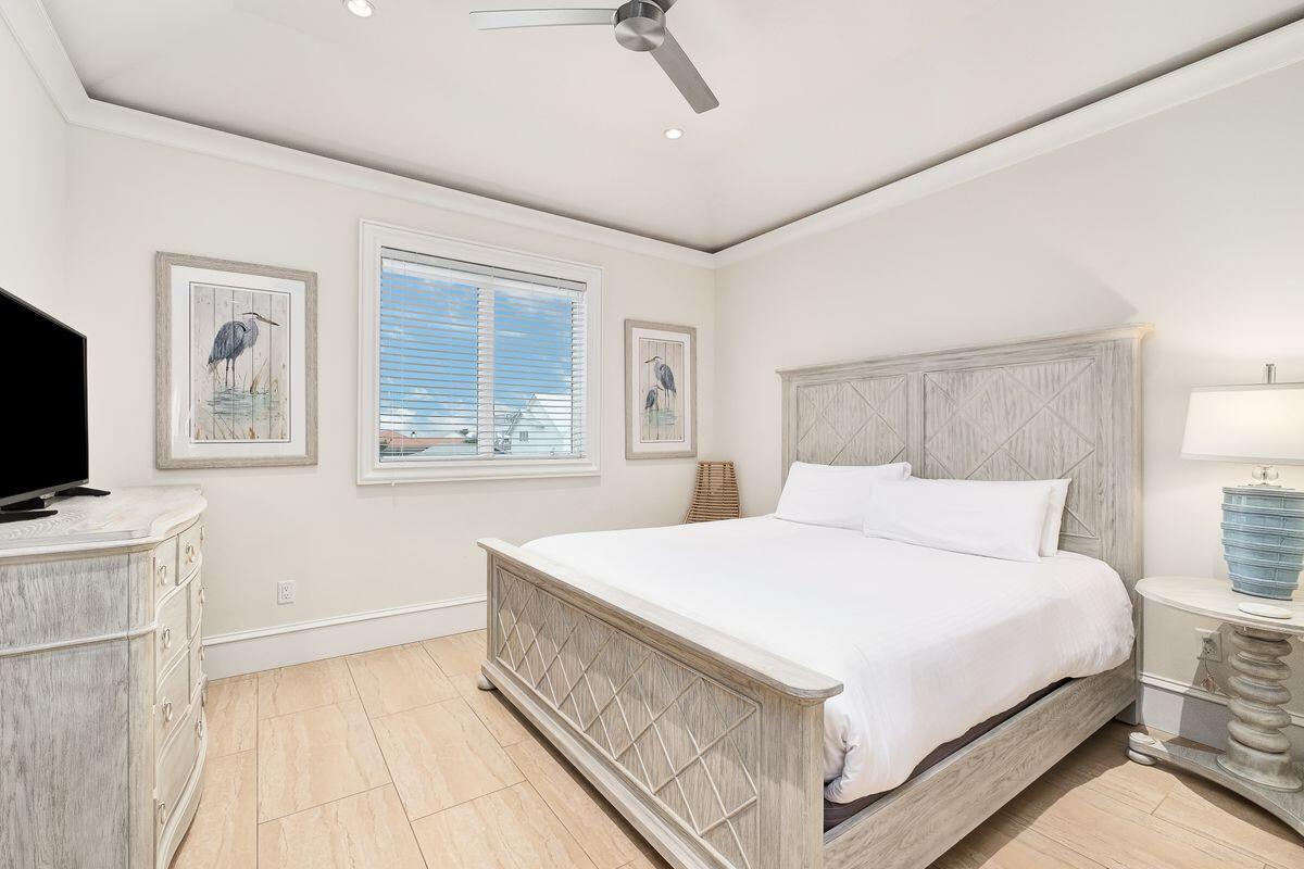 55 Sunfish Street Destin, FL 32541 - Photo 39 of 49 a bedroom with a large bed a flat tv screen and a dresser