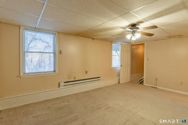 an empty room with windows and fan