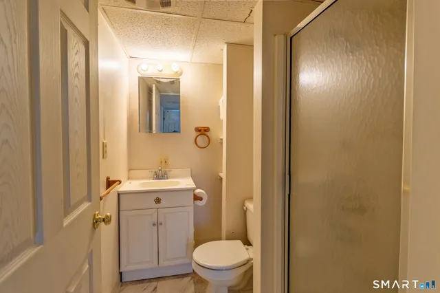 a bathroom with a toilet a sink and mirror