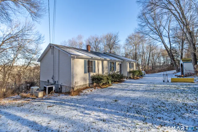 a view of a house with backyard and trees