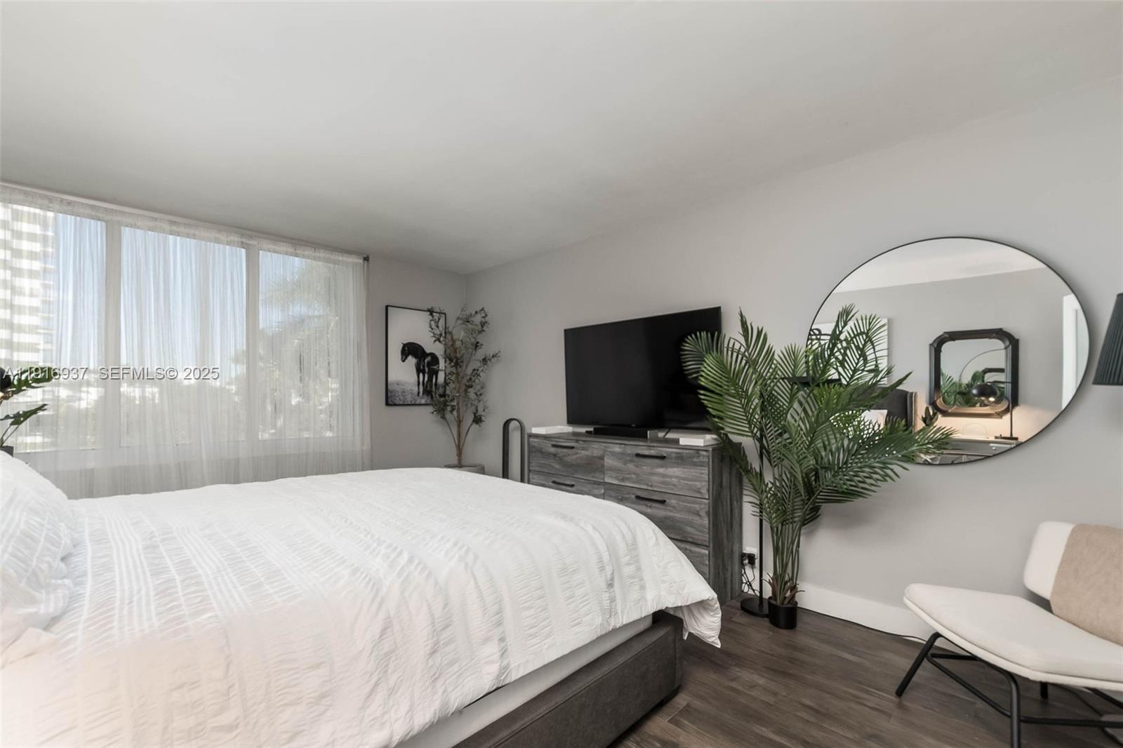 1200 West Avenue, Unit 316 Miami Beach, FL 33139 - Photo 16 of 44 a bedroom with a bed table chair and a potted plant