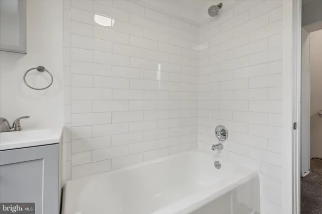a bathroom with a tub a sink and a shower