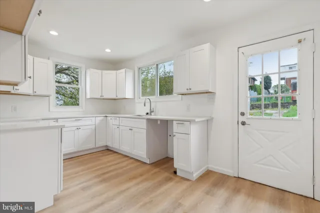 a kitchen with sink a window and cabinets