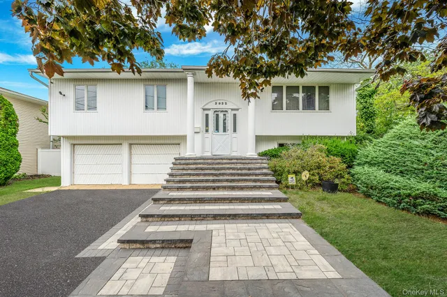 a front view of a house with a yard and a garage
