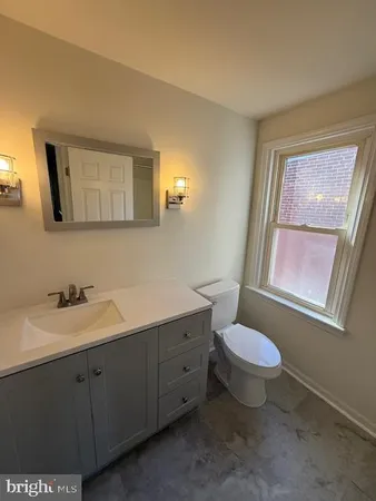 a bathroom with a toilet sink and mirror