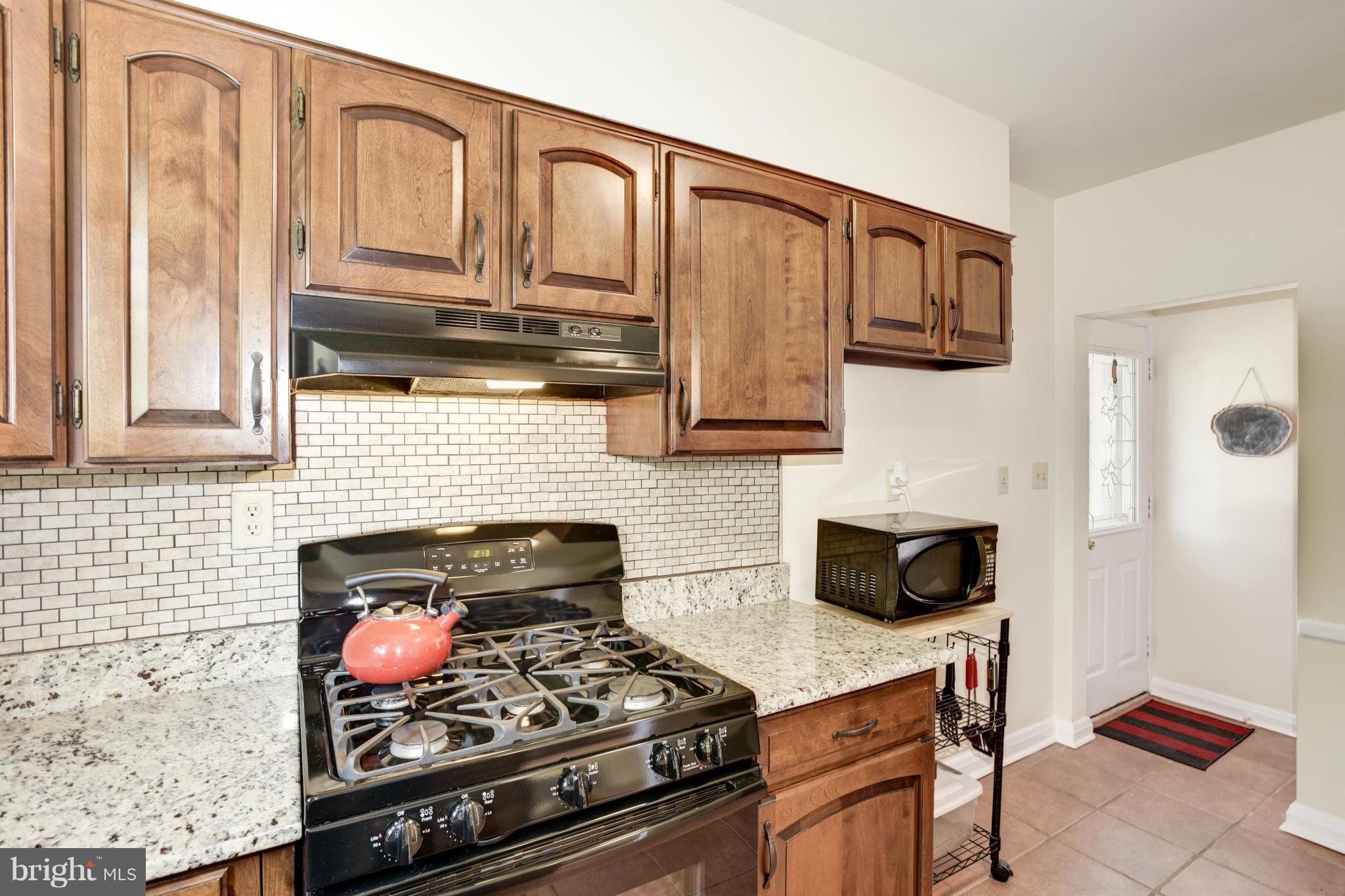 5521 Waterloo Road Ellicott City, MD 21043 - Photo 15 of 30 a kitchen with stainless steel appliances granite countertop a stove a sink and a microwave