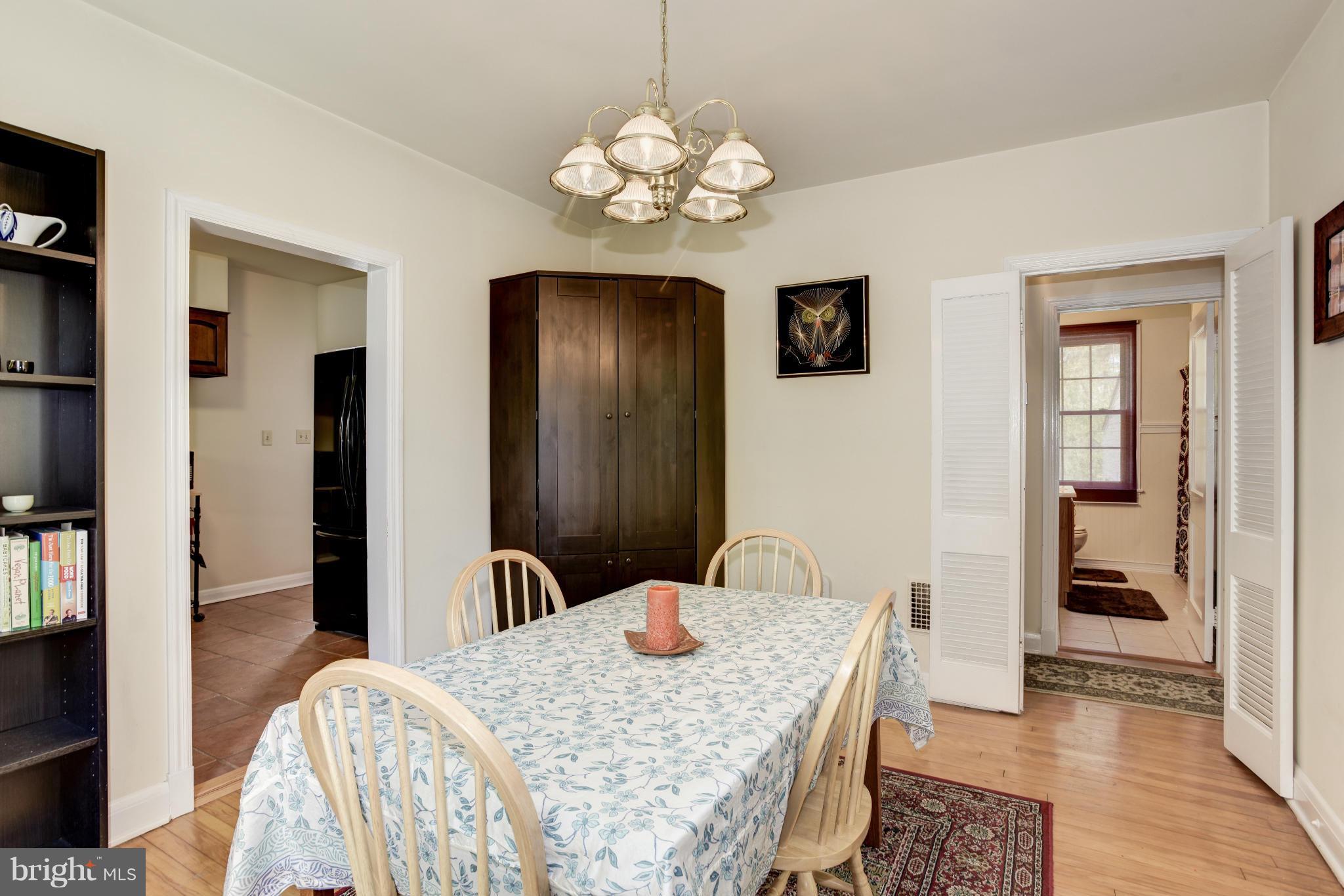 5521 Waterloo Road Ellicott City, MD 21043 - Photo 10 of 30 a dining room with wooden floor a chandelier a wooden table and chairs