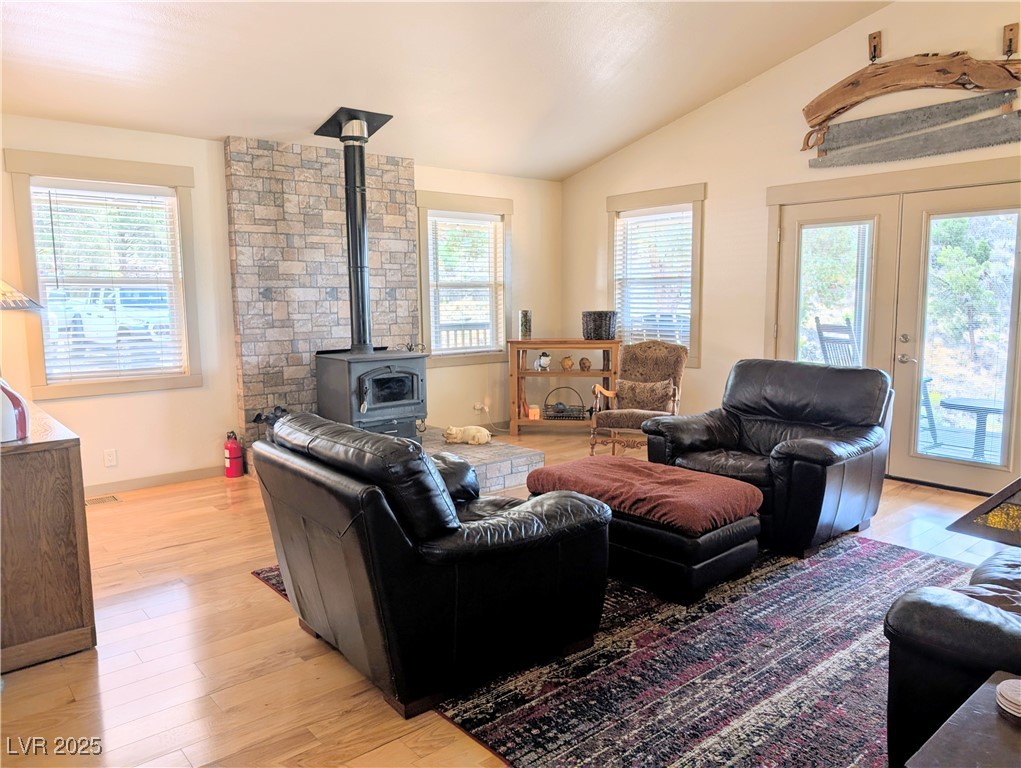 8320 Mother Lode Road Pioche, NV 89043 - Photo 25 of 46 Living area with vaulted ceiling, a wood stove, light wood floors, and french doors