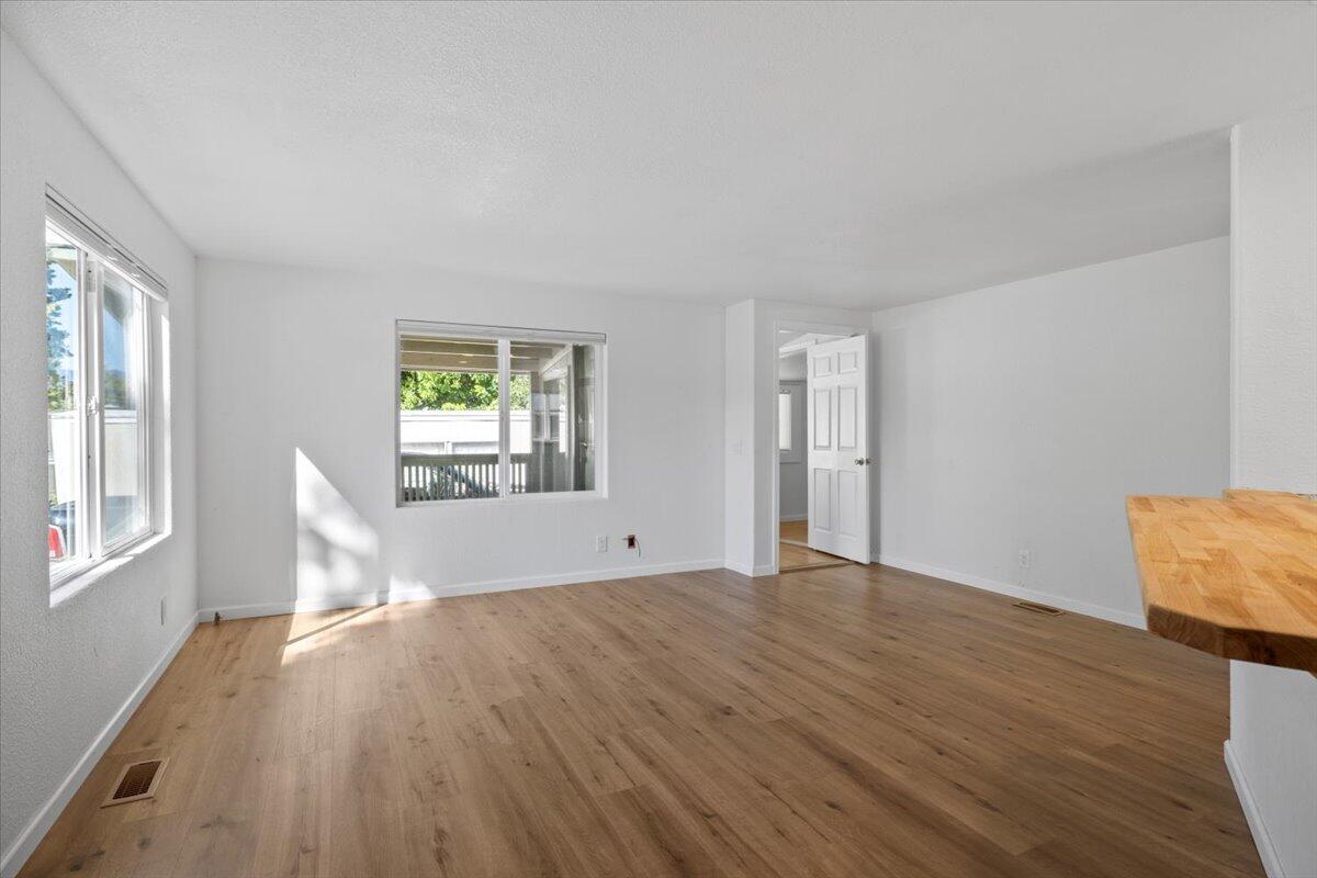 939 South Valley View Road, Unit 12 Ashland, OR 97520 - Photo 2 of 19 an empty room with wooden floor and windows