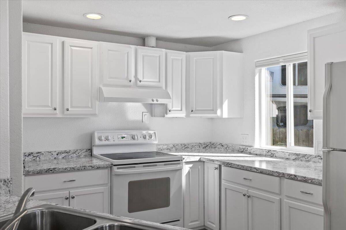 939 South Valley View Road, Unit 12 Ashland, OR 97520 - Photo 4 of 19 a kitchen with granite countertop white cabinets and white appliances