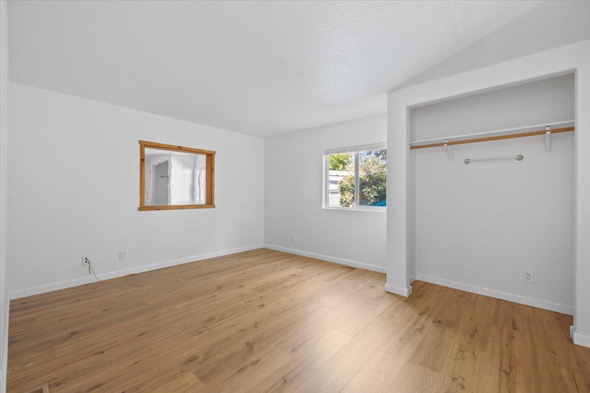 939 South Valley View Road, Unit 12 Ashland, OR 97520 - Photo 9 of 19 an empty room with wooden floor and windows