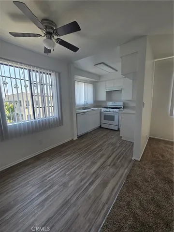 a view of a kitchen with wooden floor and electronic appliances