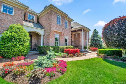 a front view of a house with a big yard and potted plants