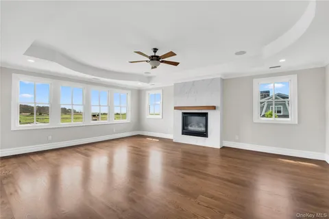 a view of an empty room with window and wooden floor
