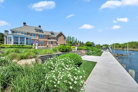 a front view of a house with a yard and potted plants