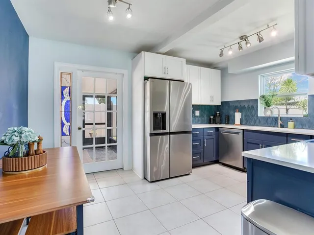 a kitchen with stainless steel appliances granite countertop a refrigerator sink and cabinets