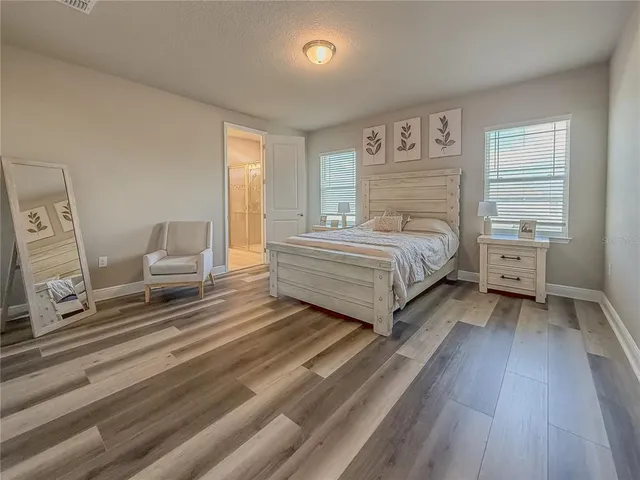 a bedroom with a bed and painting on the wall