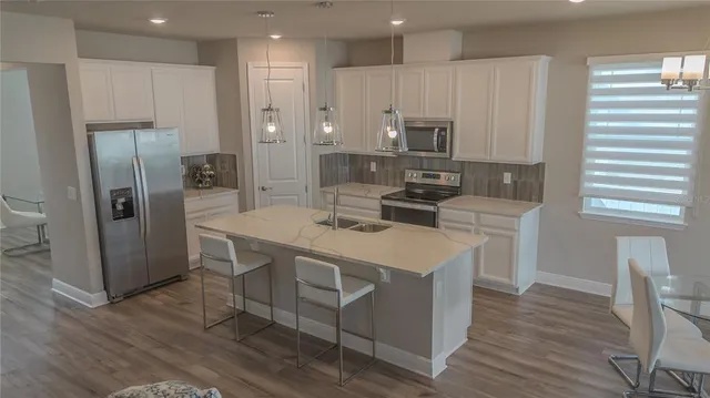 a kitchen that has a lot of counter space and stainless steel appliances