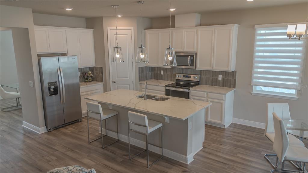 2310 Raven Rdg Drive Minneola, FL 34715 - Photo 6 of 21 a kitchen that has a lot of counter space and stainless steel appliances