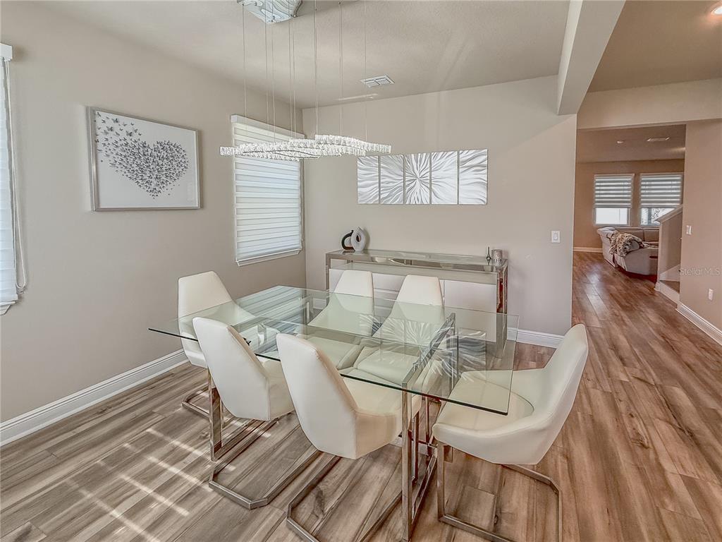 2310 Raven Rdg Drive Minneola, FL 34715 - Photo 7 of 21 a view of a dining room with furniture and wooden floor
