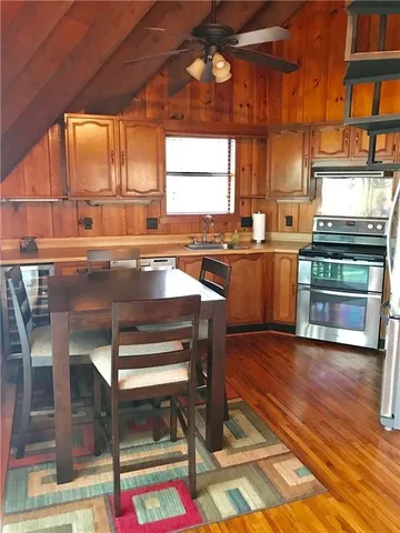 a kitchen with stainless steel appliances granite countertop a stove a sink and a microwave