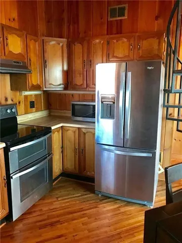 a kitchen with granite countertop stainless steel appliances and wooden floor