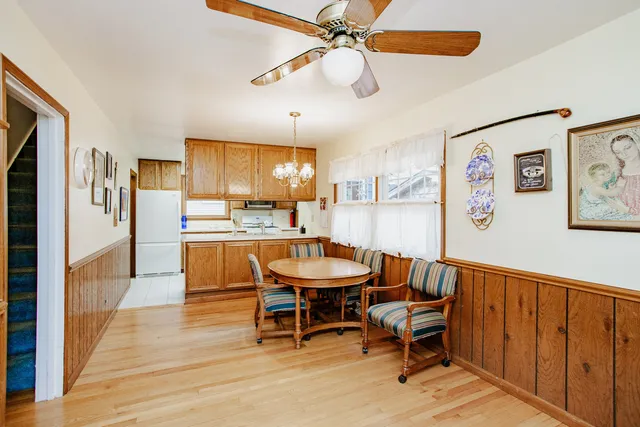 a dining room with stainless steel appliances kitchen island granite countertop furniture and a window