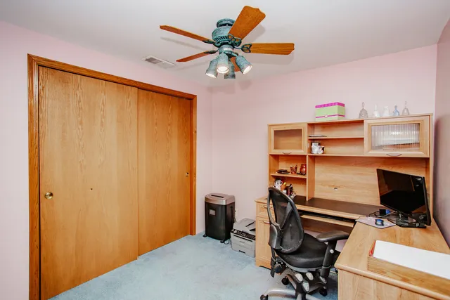 a view of a workspace with furniture and a window