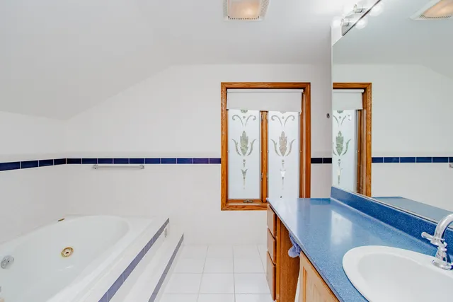 a bathroom with a tub sink and mirror