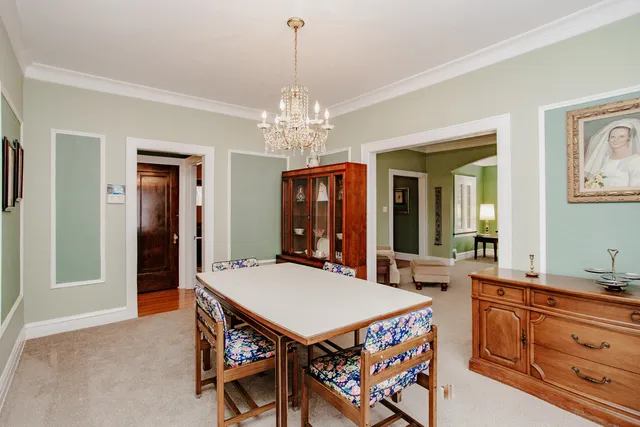 a view of a dining room with furniture and chandelier