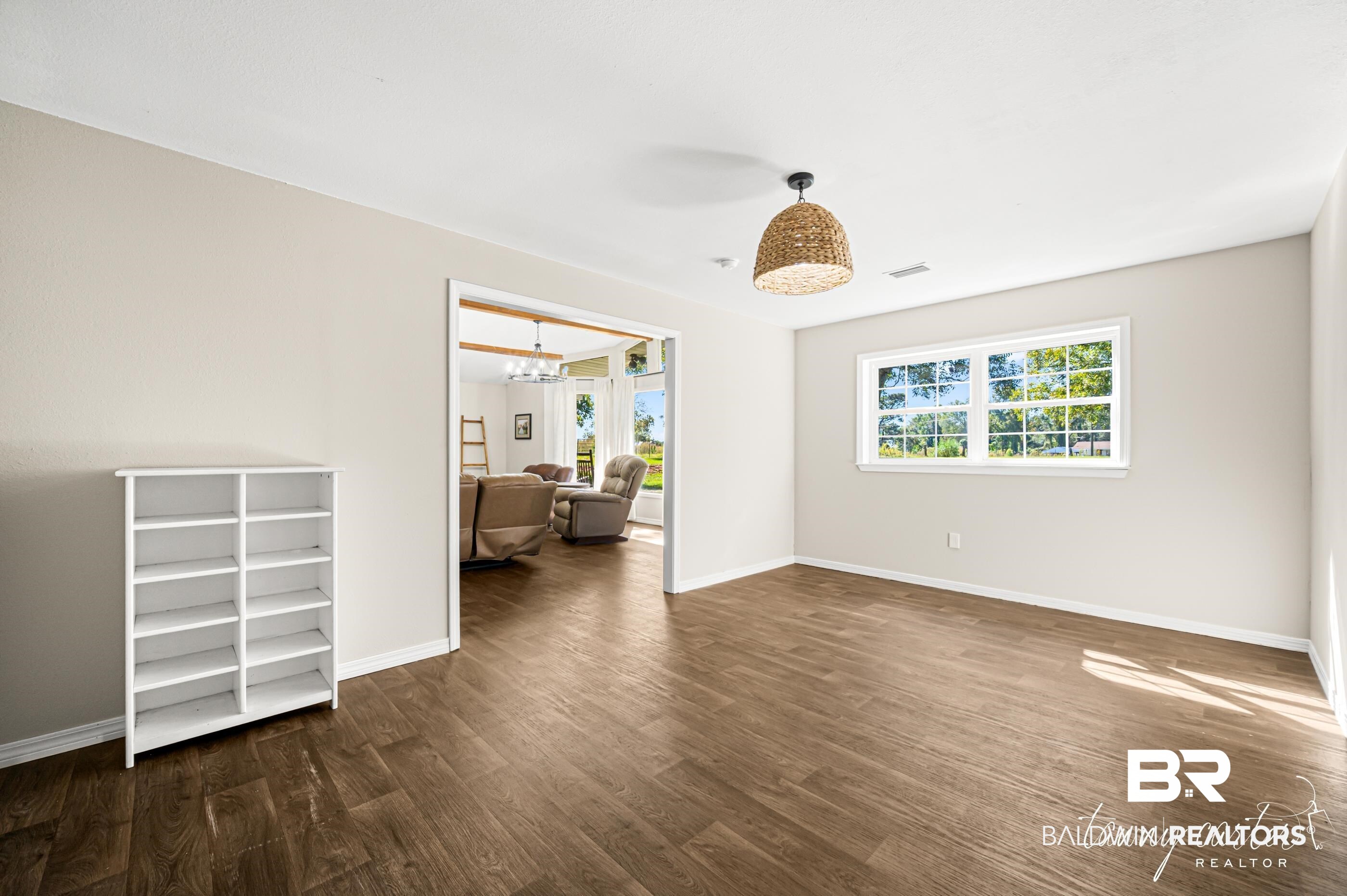 3086 Wild Fork Road Frisco City, AL 36445 - Photo 7 of 30 Spare room featuring plenty of natural light, dark wood-style floors, and a chandelier