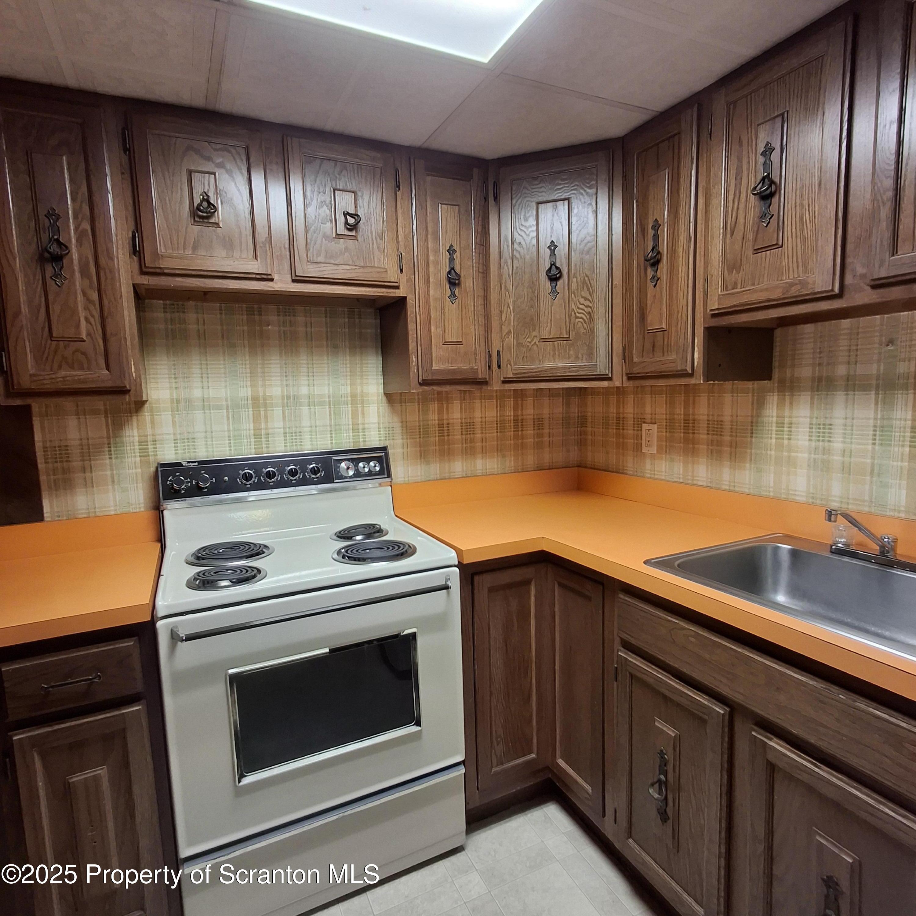 200 Poplar Street, Unit L 6 Archbald, PA 18403 - Photo 11 of 28 a kitchen with granite countertop wooden cabinets stainless steel appliances and a counter space