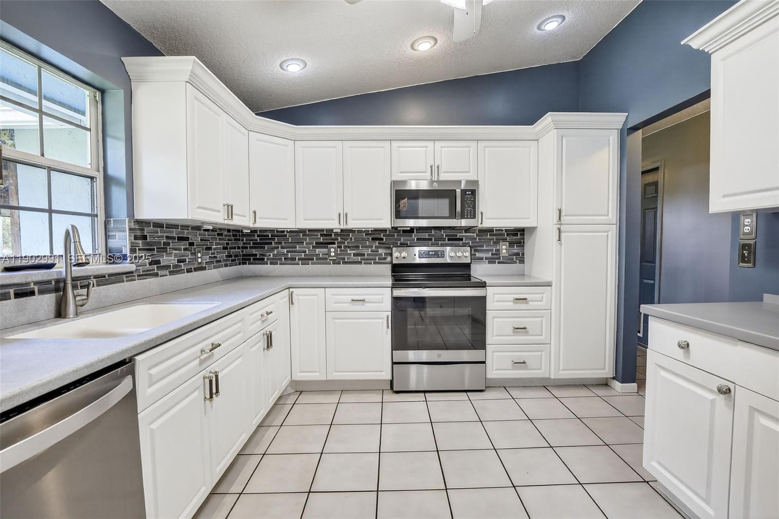 5010 Southwest 201st Terrace Southwest Ranches, FL 33332 - Photo 11 of 50 a kitchen with stainless steel appliances a stove sink and microwave