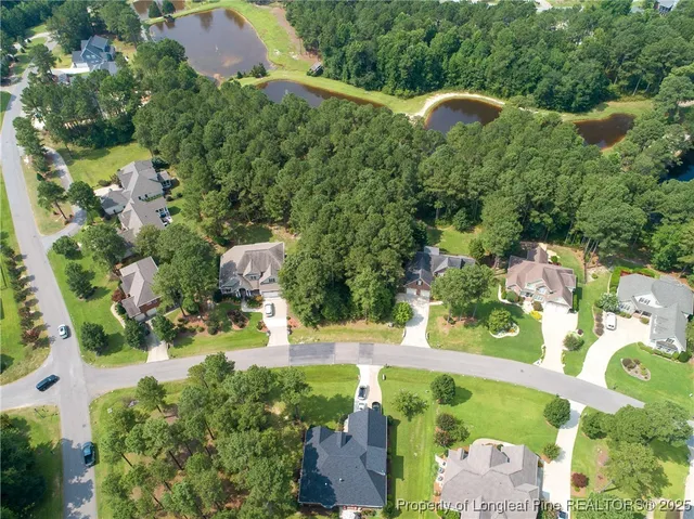an aerial view of a house with a yard and lake view