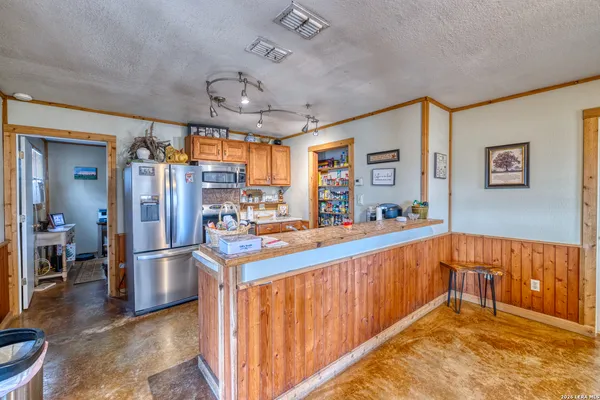 a kitchen with stainless steel appliances granite countertop a refrigerator a sink and white cabinets