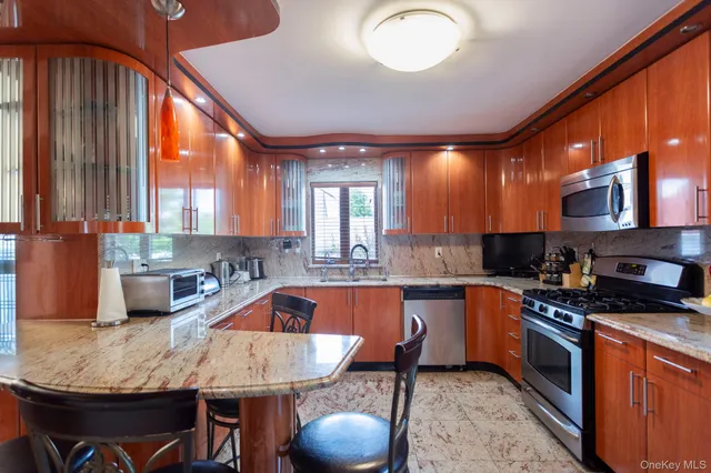 a kitchen with granite countertop a sink a counter space appliances and cabinets