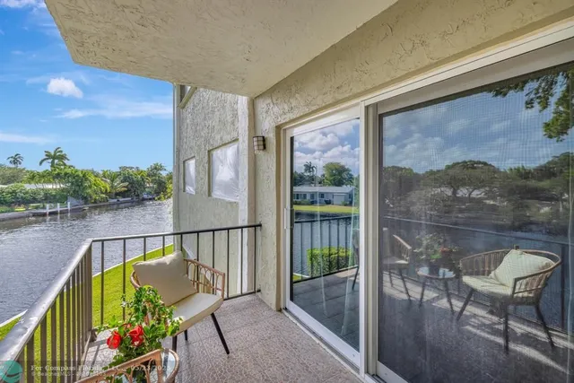 a view of a balcony with furniture and a garden
