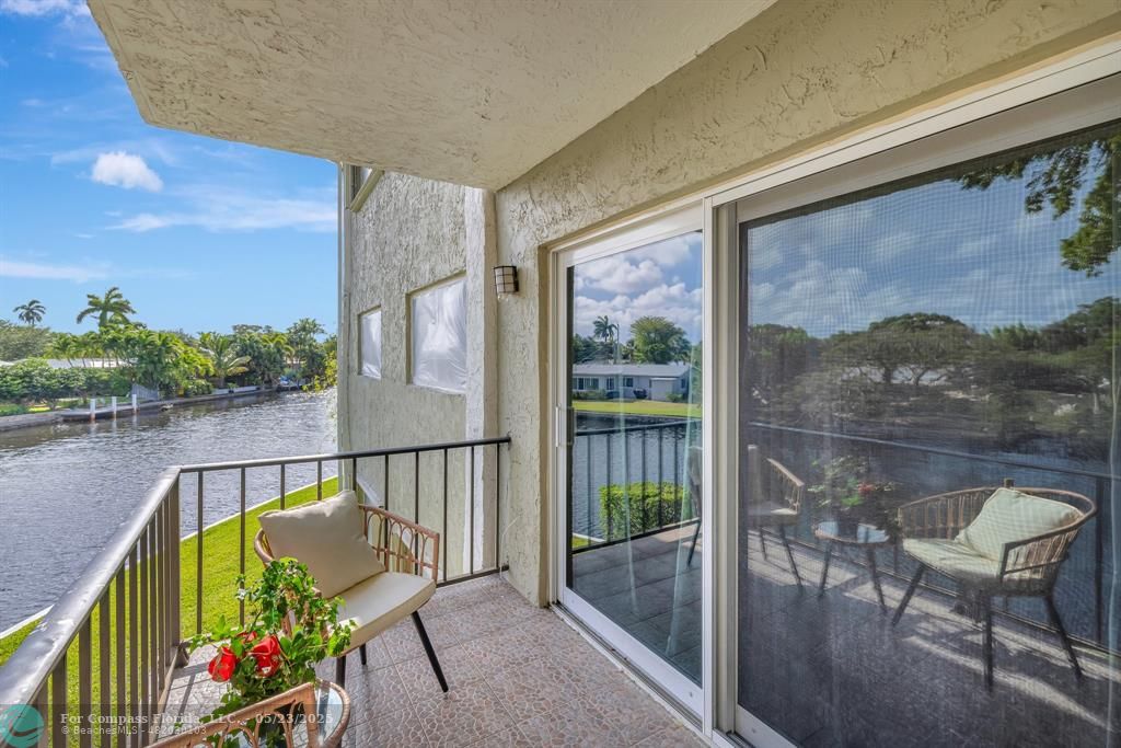 a view of a balcony with furniture and a garden