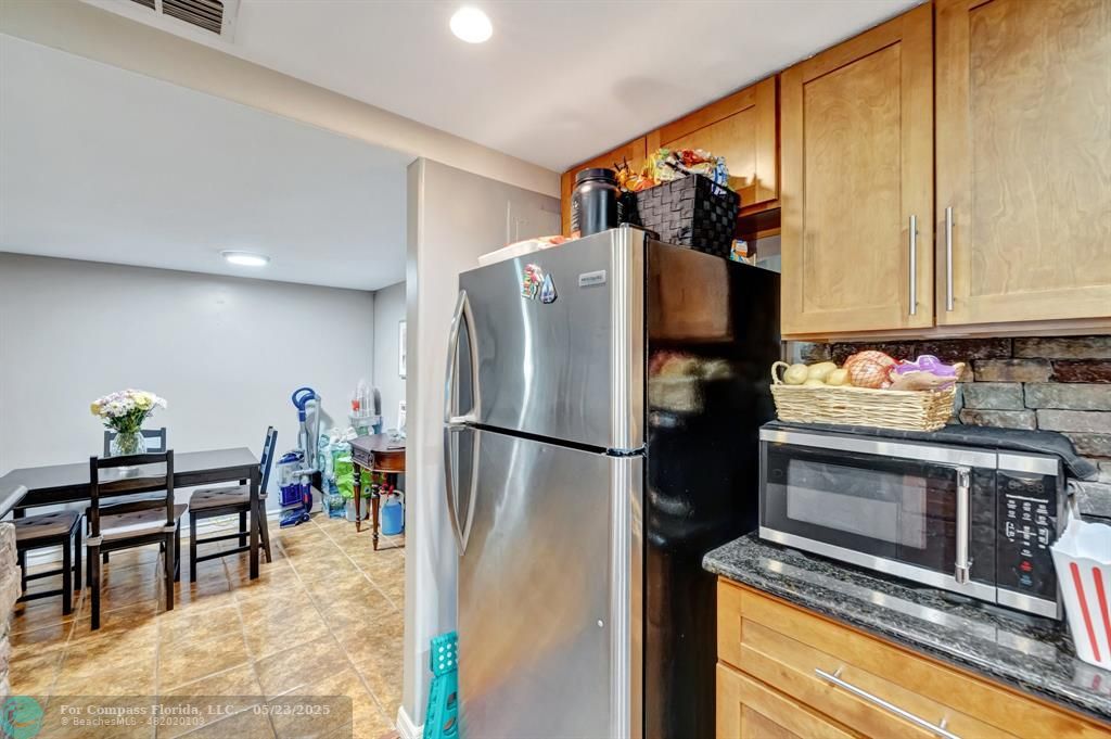 3004 Northeast 5th Terrace, Unit 208C Wilton Manors, FL 33334 - Photo 12 of 63 a kitchen with stainless steel appliances a refrigerator and a stove top oven