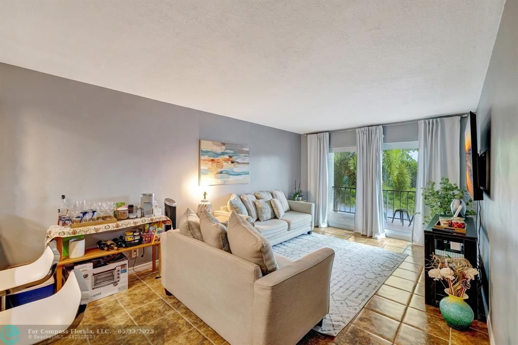 3004 Northeast 5th Terrace, Unit 208C Wilton Manors, FL 33334 - Photo 13 of 63 a living room with furniture and a large window