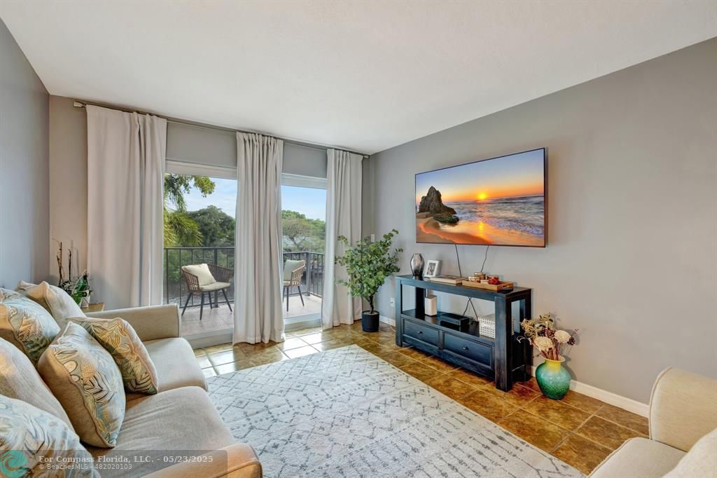 3004 Northeast 5th Terrace, Unit 208C Wilton Manors, FL 33334 - Photo 16 of 63 a living room with furniture and a flat screen tv