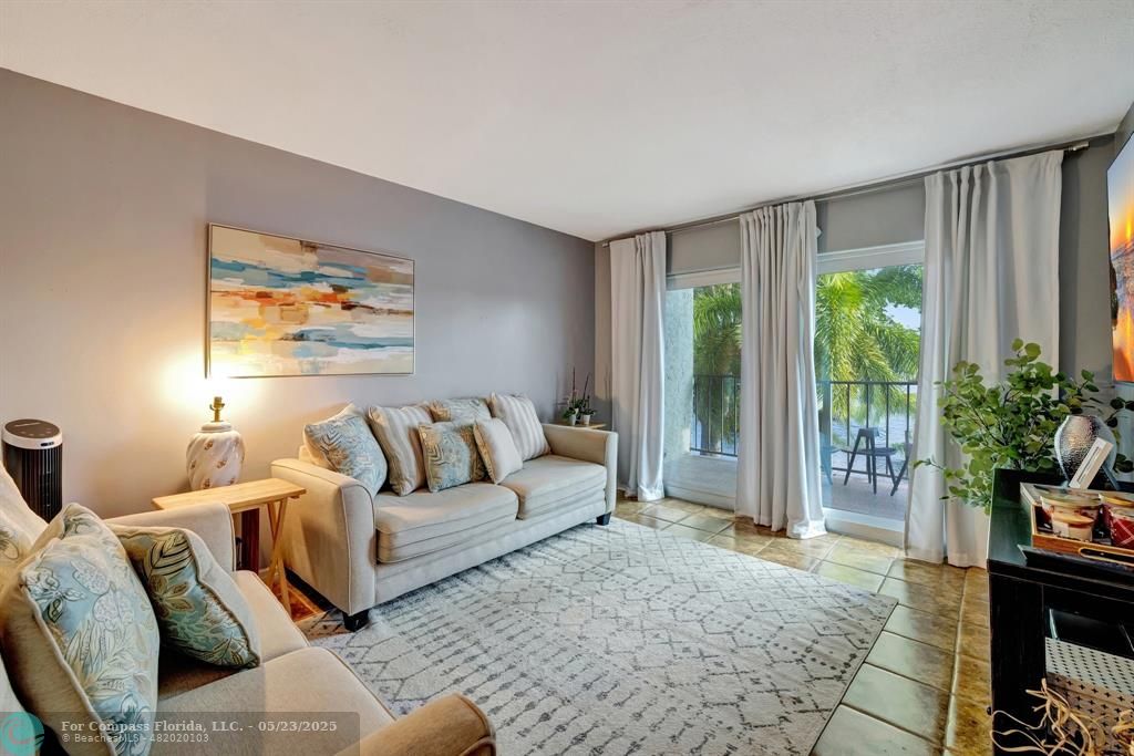 3004 Northeast 5th Terrace, Unit 208C Wilton Manors, FL 33334 - Photo 17 of 63 a living room with furniture and a large window